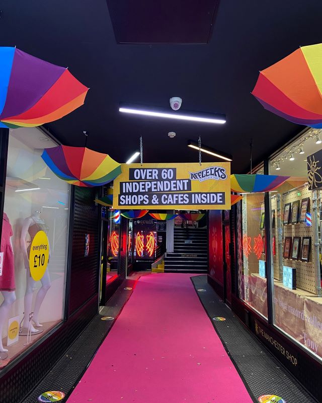 colorful umbrella hung upside down in an alley with pink carpet- 30 Unique Things to Do in Manchester UK