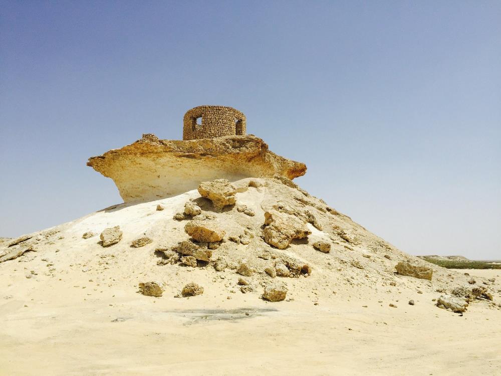 rock formation in middle of desert - Things to Do in Doha