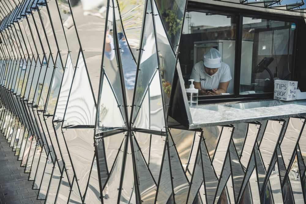woman holding her phone in the window showing grey structure building