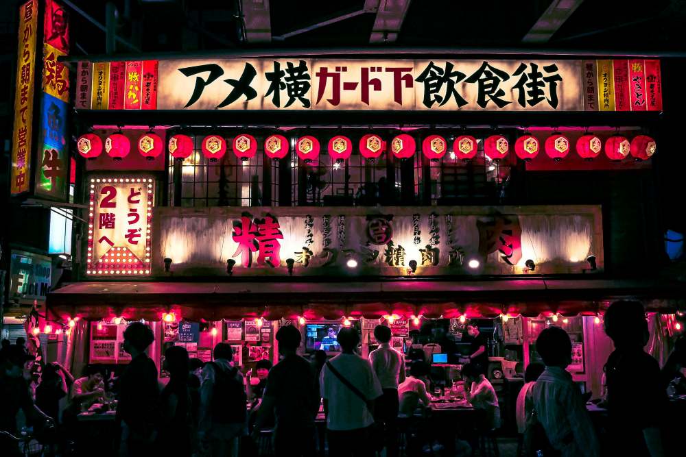 people in front of a food out door resto with light signage