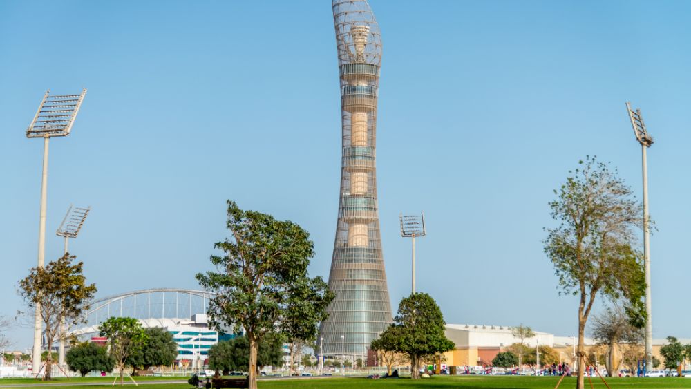 high-rise tower surrounded by other buildings and green trees