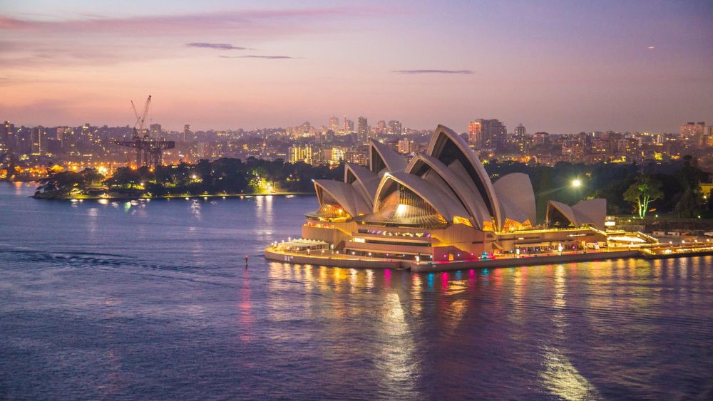 sydney opera house light up near body of water