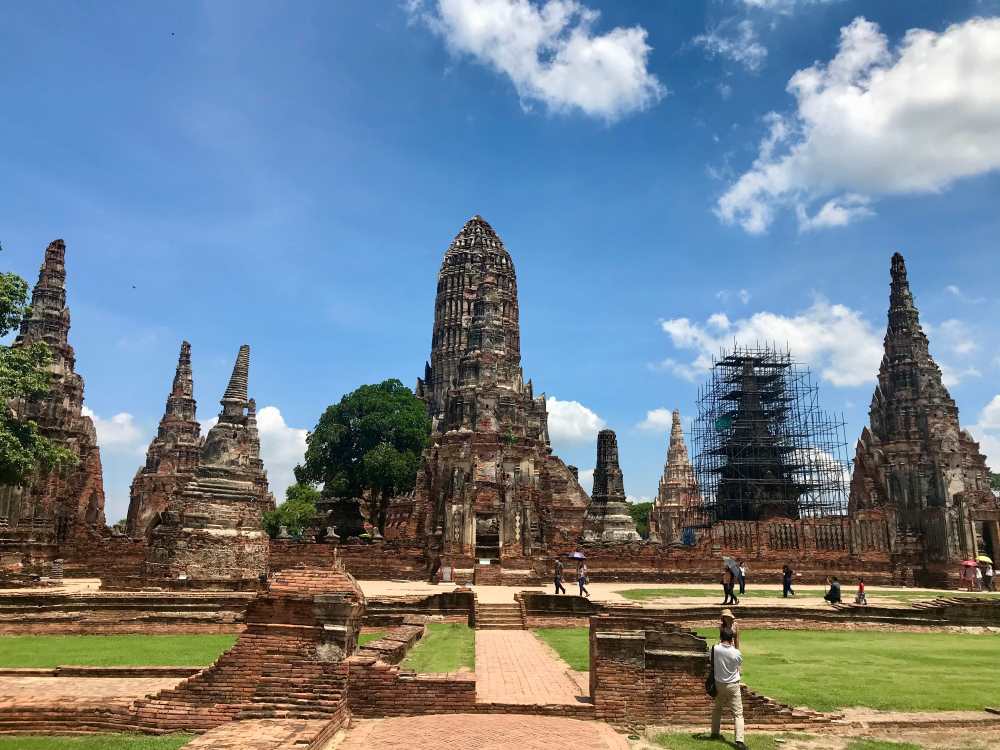 brown old structure with people waking in it - best places to visit in thailand
