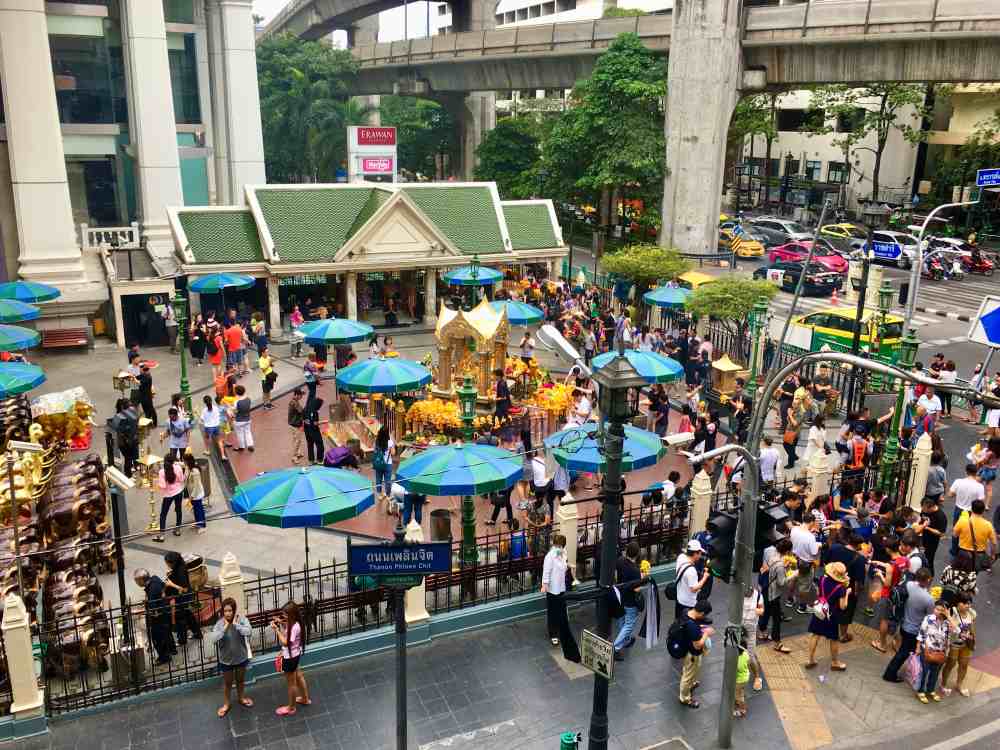 crowded street with golden small structure in the middle of the street
