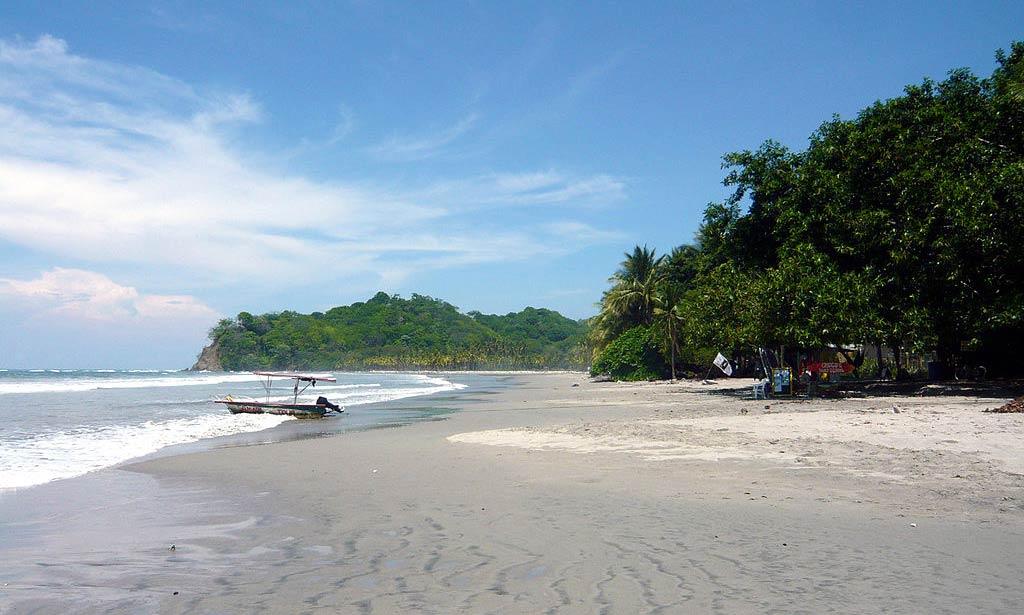 sandy Playa Samara, Guanacaste beach with boat at the seaside