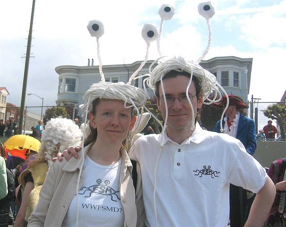 a couple celebrating san fancisco saint stupid's day parade in  flying spaghetti monsters headpiece