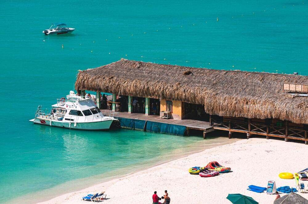 white yatch beside the nipa hut made restaurant floating at the seashore