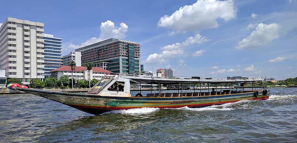 sailing boat in the river near the buildings