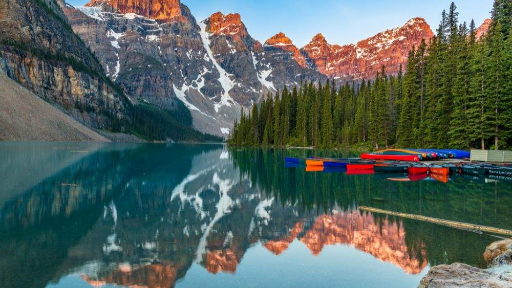 lake view with green trees on the side and mountain background- canada digital nomad visa