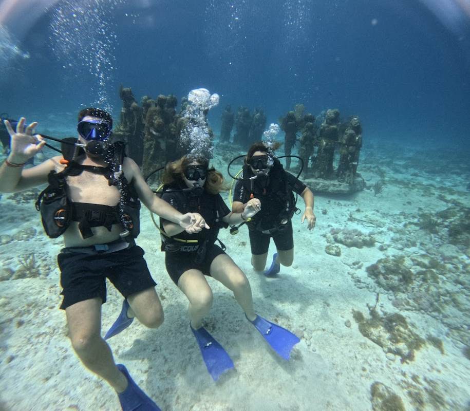 my husband, daughter and I scuba diving with statue in our back - Is Cancun Safe for Tourists? 2024 Top Safety Tips