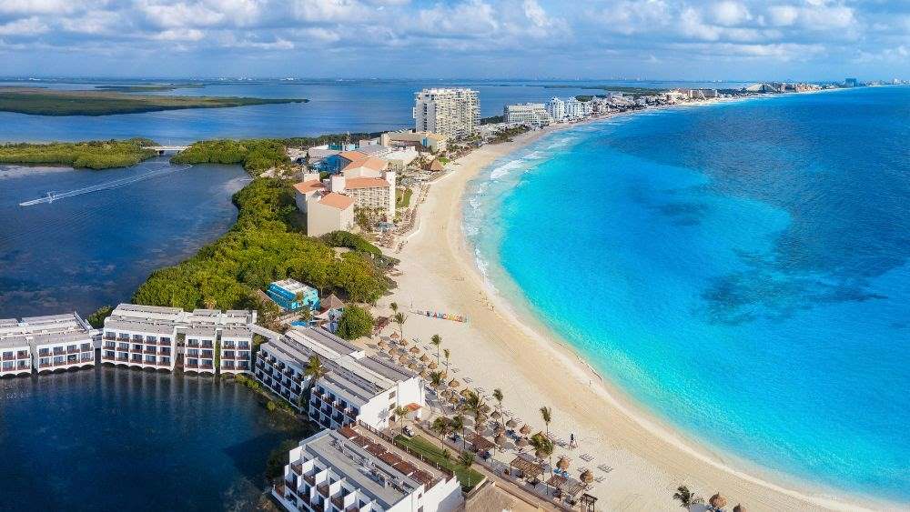 aerial view of a city with resort and tall buildings in the middle of body of water