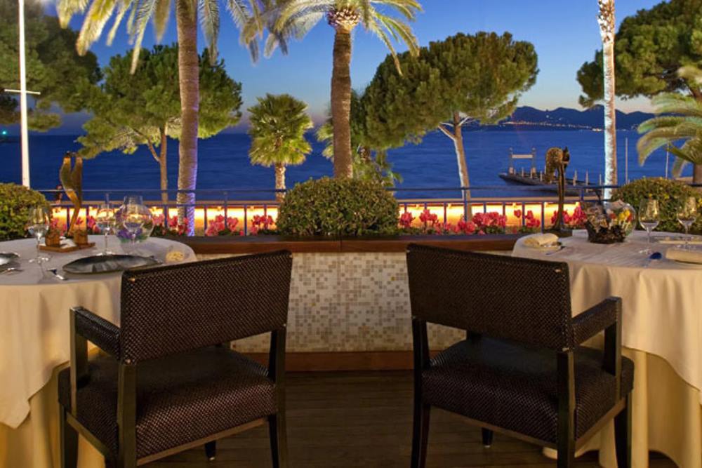 tables and chairs set up in front of the ocean -Best Things to Do in Cannes