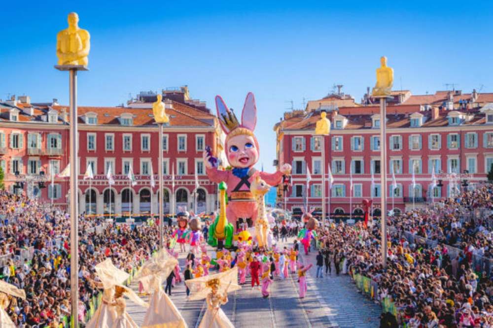 image of a parade in the street with people dancing and with big baby mascot in the middle