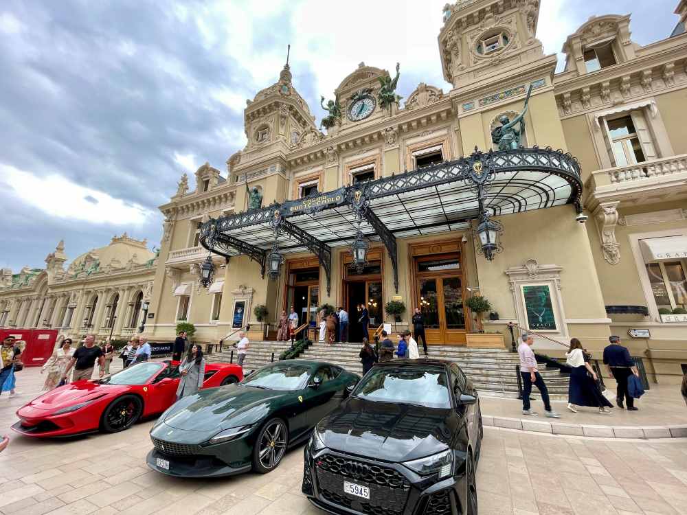 luxury cars park in front of an old structural building 