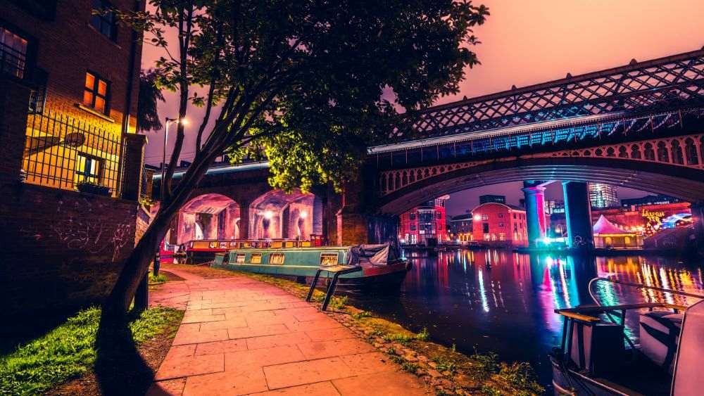 colorful light of a bridge with boats in the edge of the alley