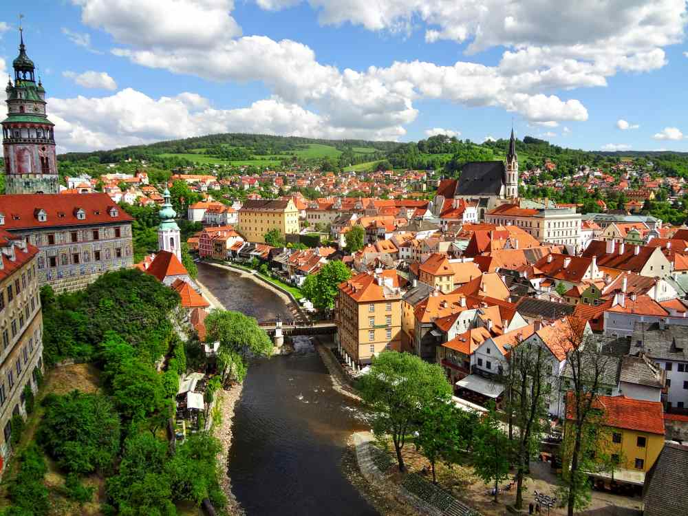 top view of the city with same looking houses with river in between and green trees- czech republic digital nomad visa