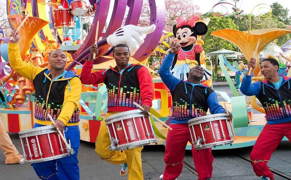 four drummers dancing along with minnie mouse in a parade