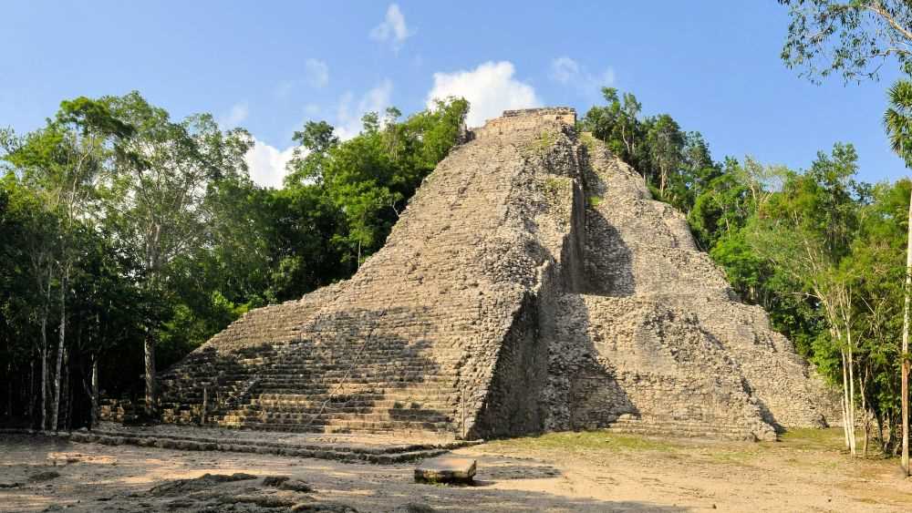 large pyramid surrounded by green tall trees- Best Things to Do in Cancun Mexico