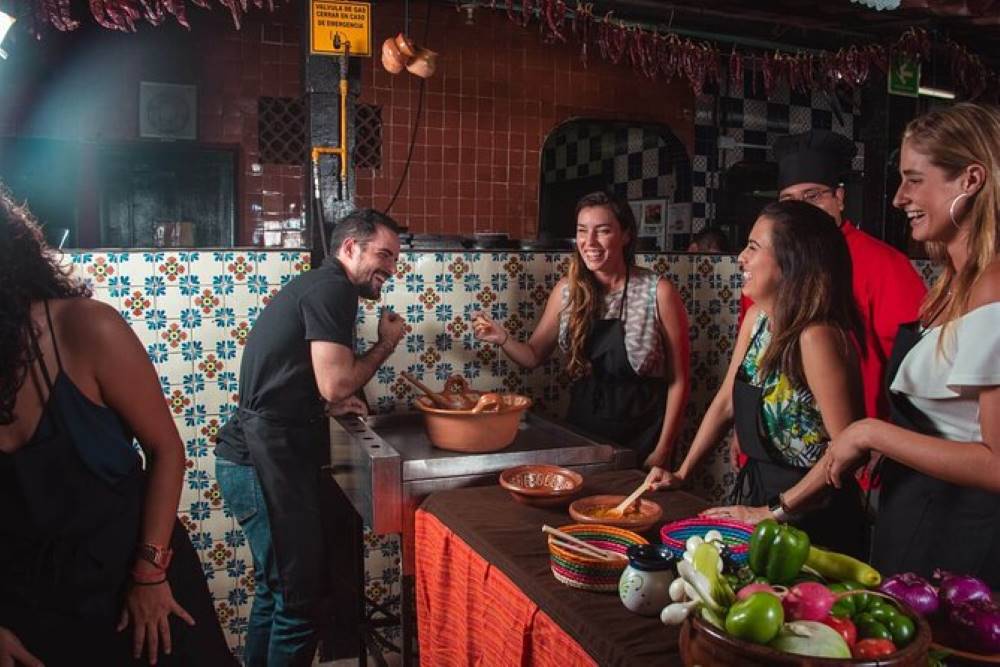 group of people laughing while cooking
