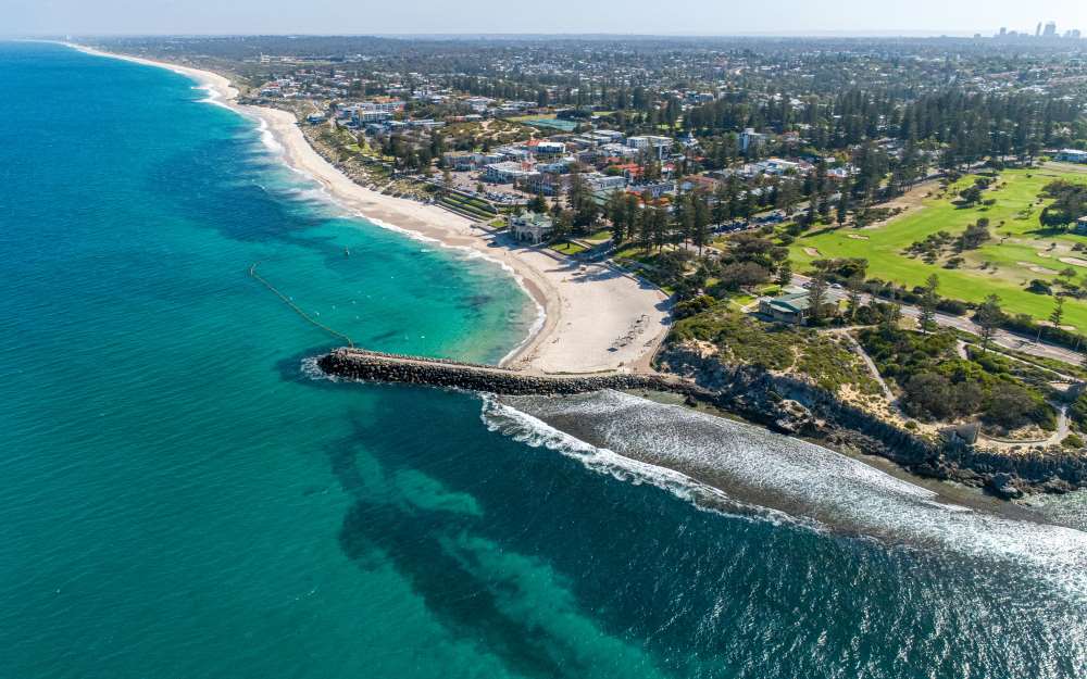 aeiral view of a city surrounded by green trees and in front of the ocean - Best Beaches in Australia