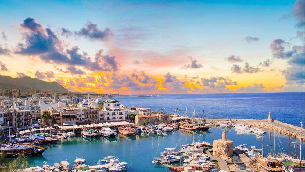 aerial view of the city showing buildings and houses with a lot of boats and yatch in the ocean