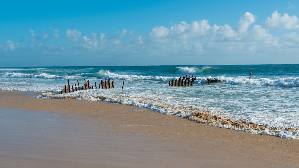 old boat structure in the ocean shore - Best Beaches Near Brisbane