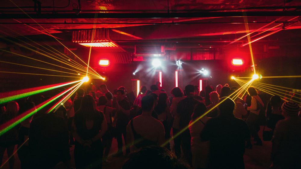 group of people inside a bar partying with different color lights