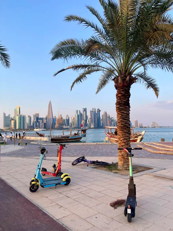 scooter at tyhe pathway showing the body of water and high rise buildings