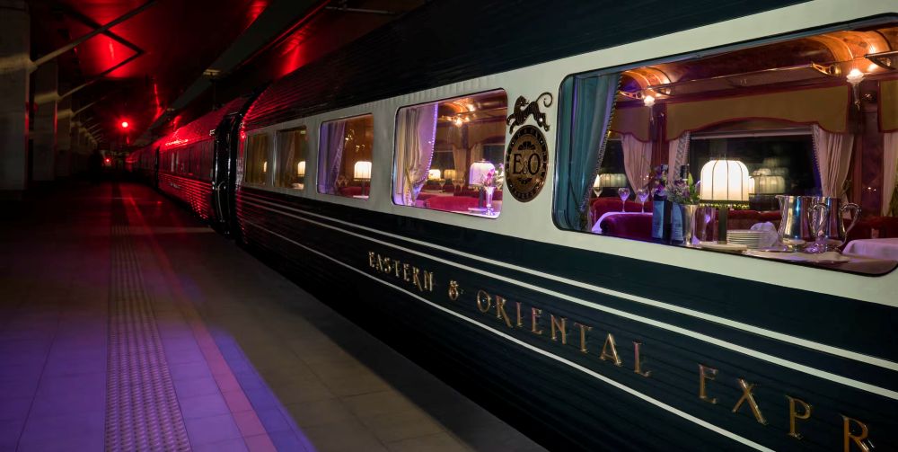 train with glass window showing inside tables and chairs
