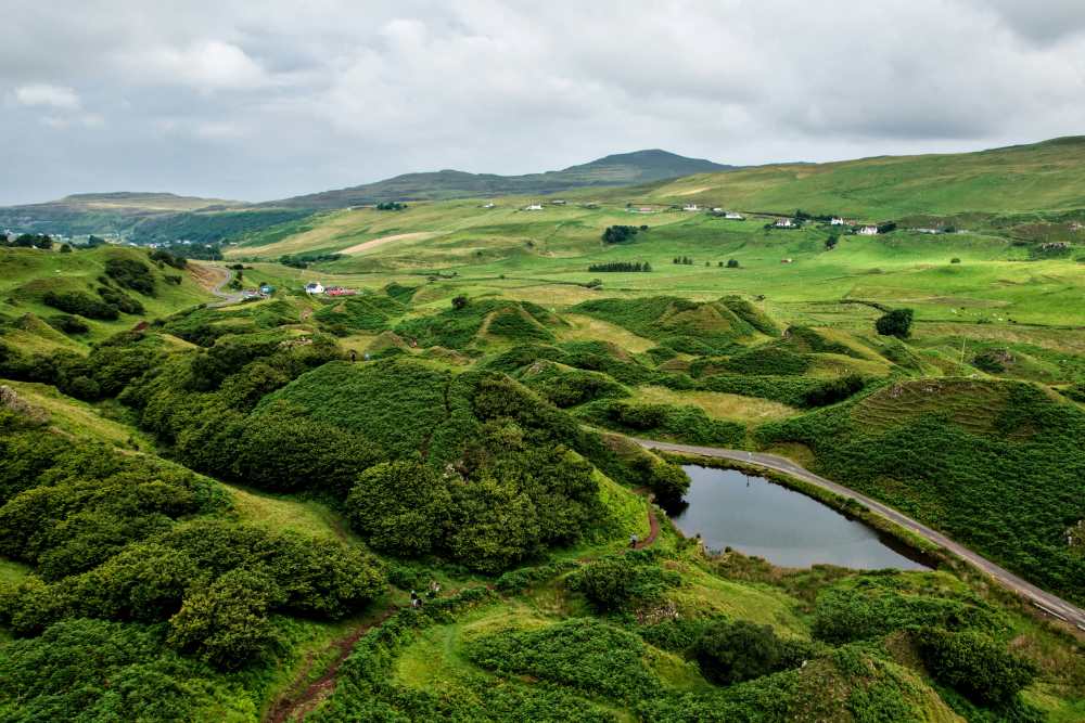 green grass landscape with body of water in the middle- Things to Do in Scotland