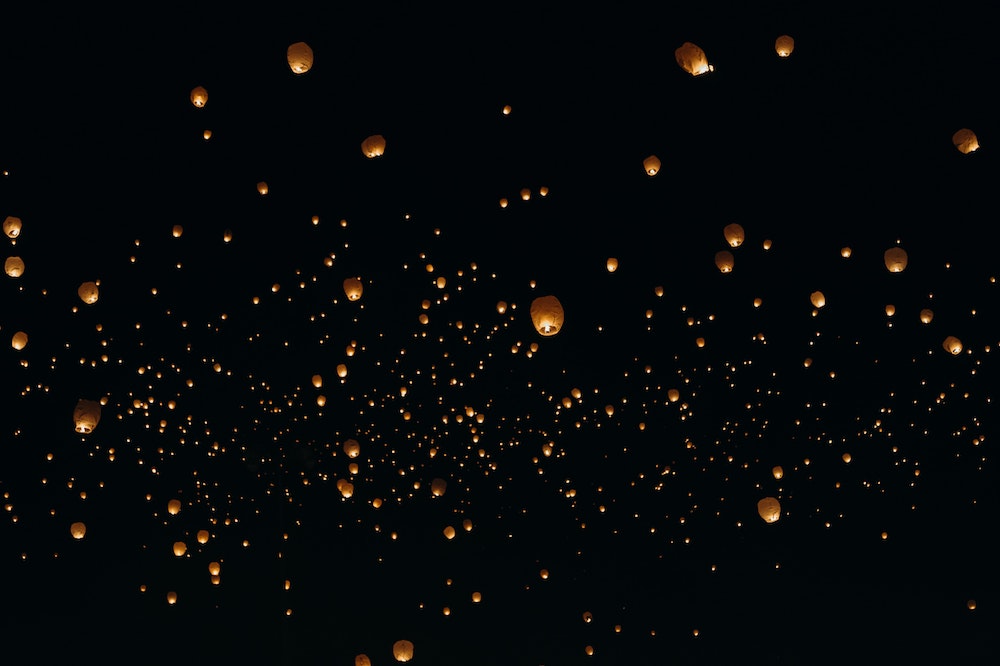 Flying lantern in the sky during night time