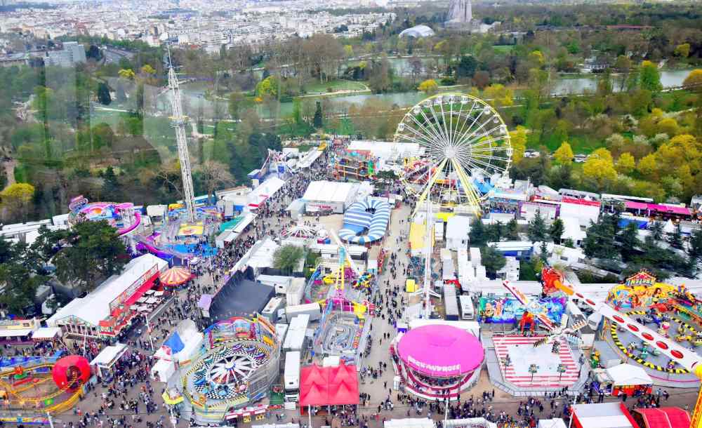 Aerial view of carnival full of people and different kinds of rides during daytime