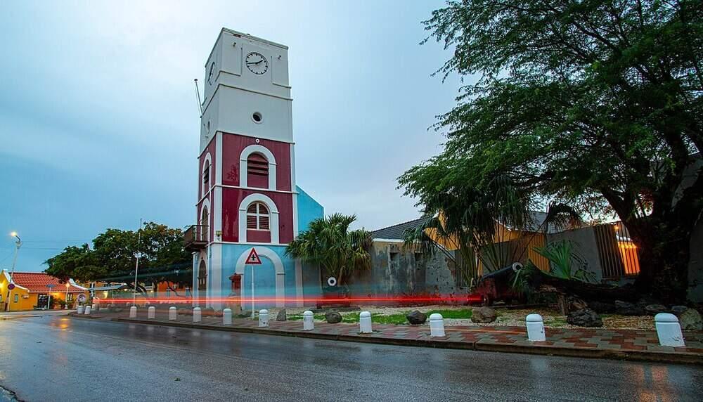 side view of a white red and blue building beside the road known as Fort Zoutman