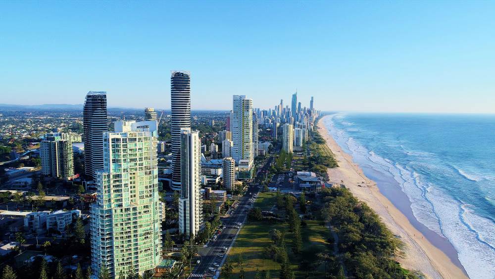 tall buildings and community in front of the wavy ocean