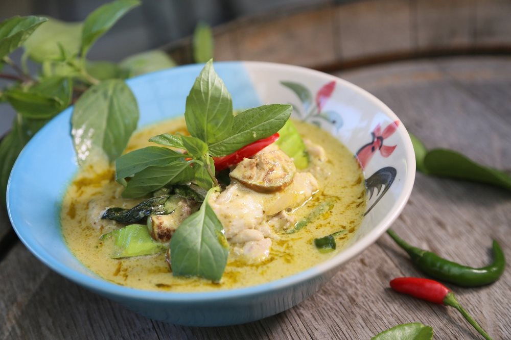 green curry soup with green leaves on top best thai food in thailand