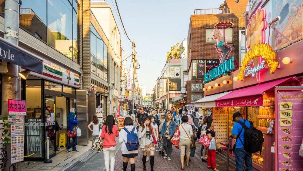 crowded street with different colorful signage on top of stores - best things to do in Tokyo
