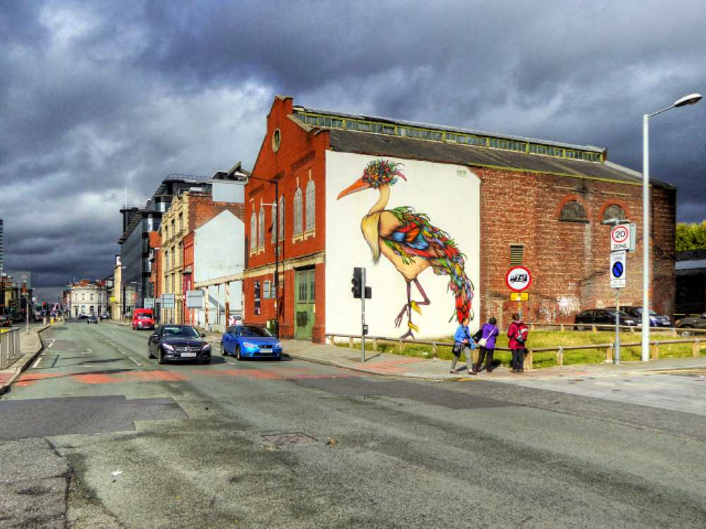 art mural in the wall of a building near the street