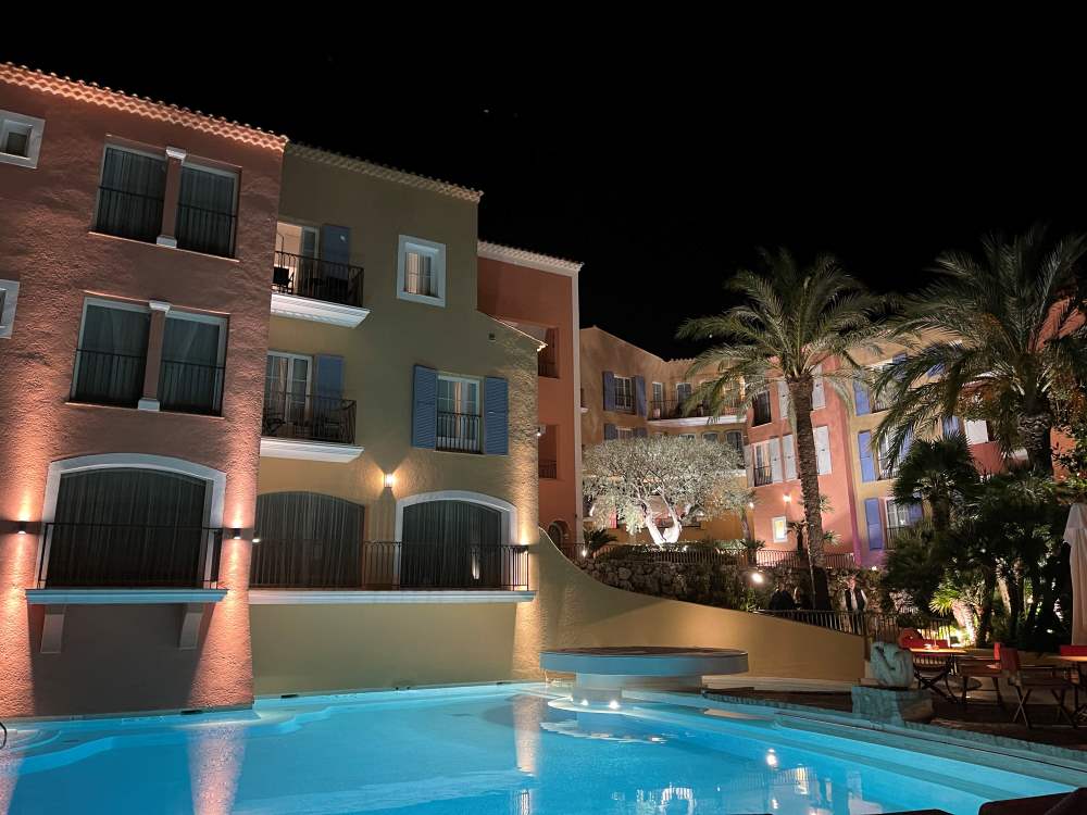 hotel with pool in front and palm trees
