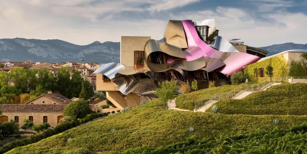 futuristic design roof of a building surrounded by other houses and fields - unique hotels in the world