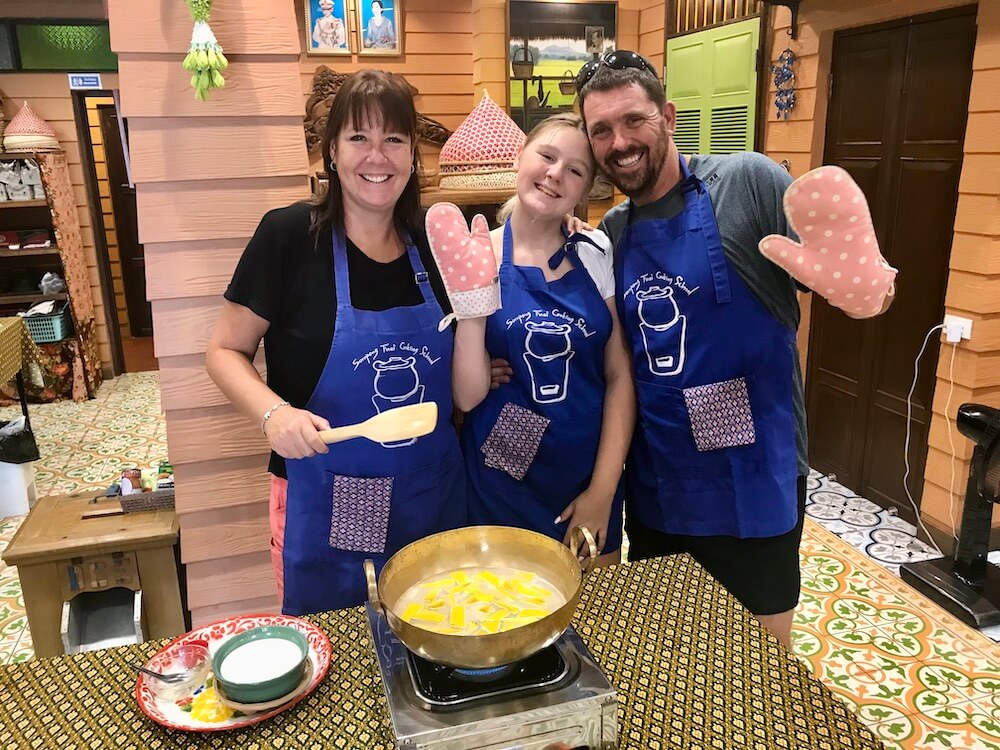 My family wearing blue apron and posing for a picture during our cooking class