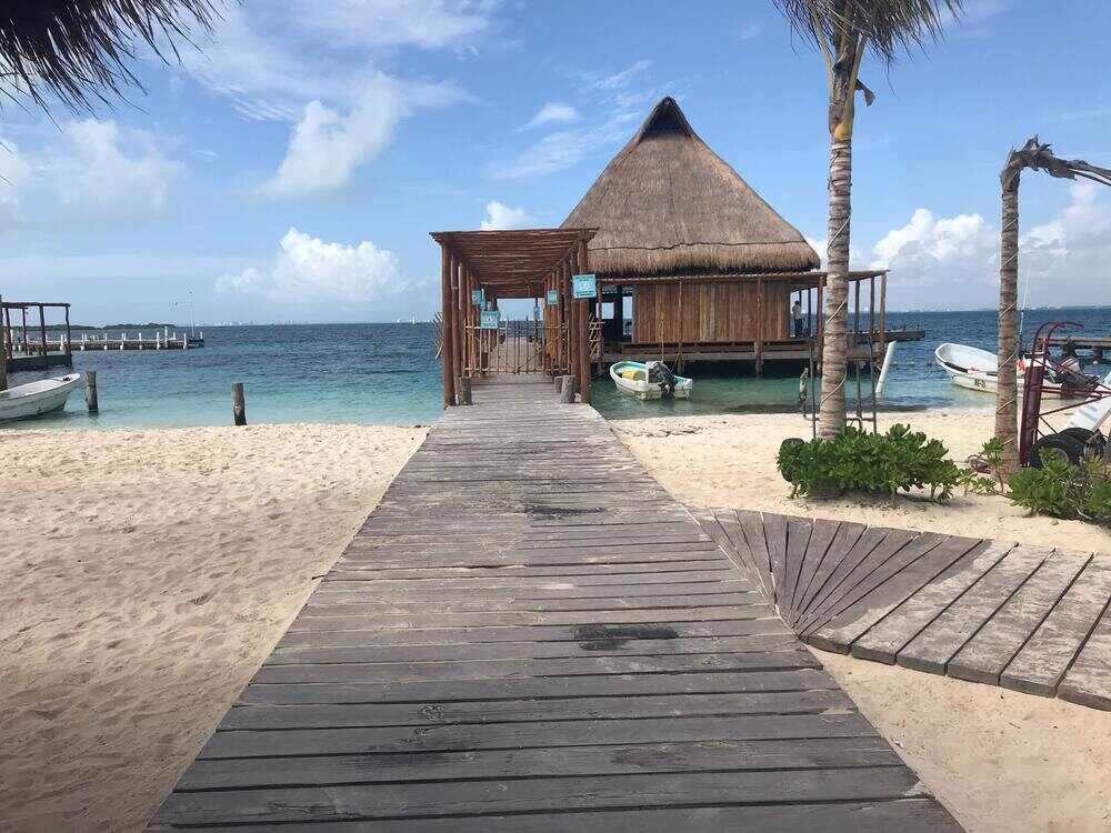 Wooden bridge going to a nipa hut cottage on the side of the beach shore