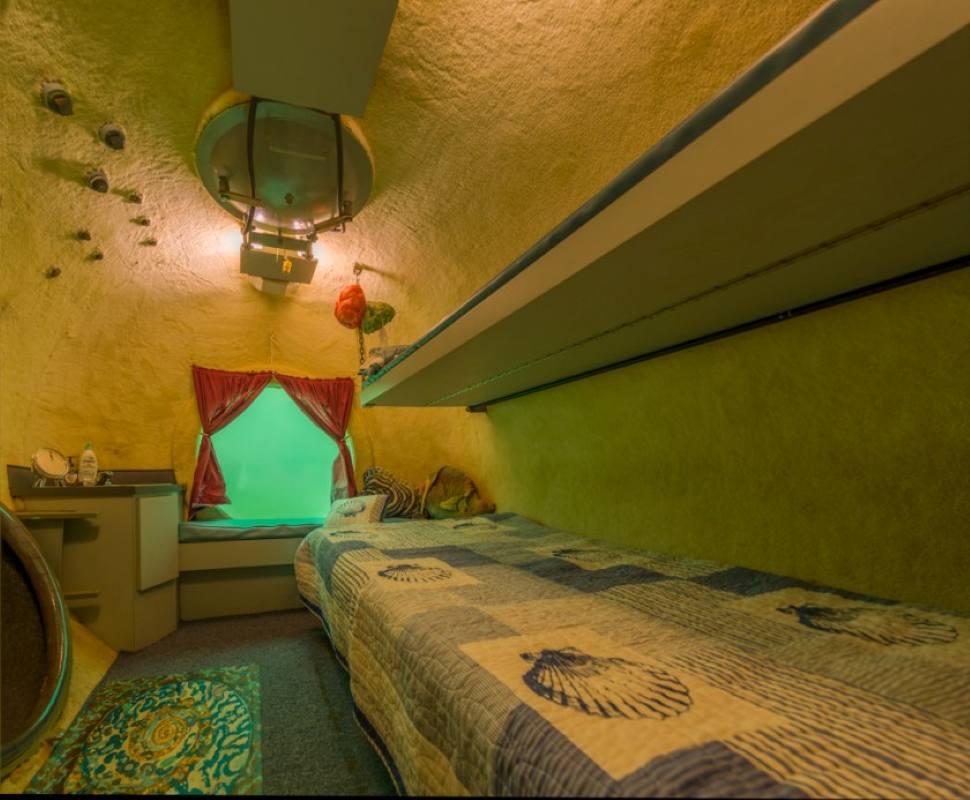 room underwater with circle window showing outside water - unique hotels in the world