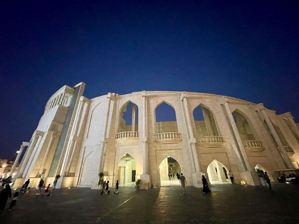 people walking around in a huge off white building during night time