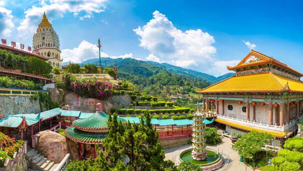 aerial view of a Kek Lok Si Temple surrounded by green trees and mountains