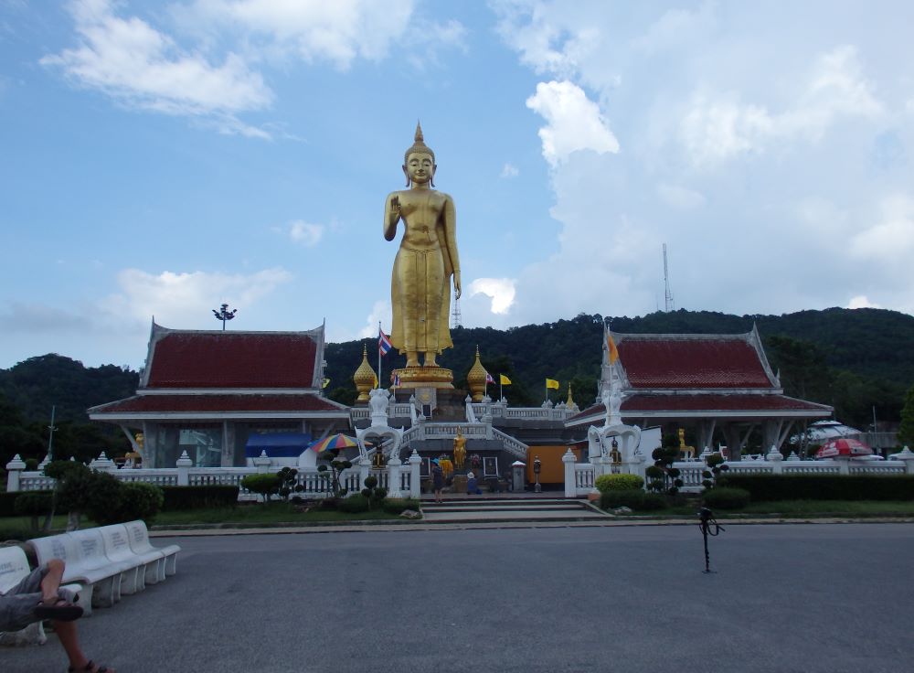 big golden statue on top of the roof of a structure in the middle of the street