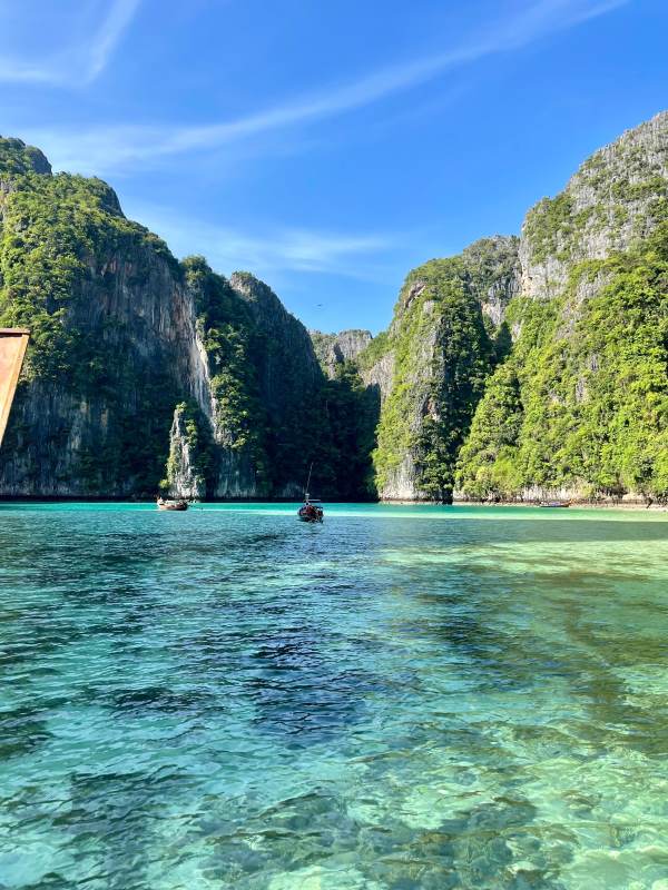 crystal clear green beach with green rock mountain in the background-best places to visit in thailand