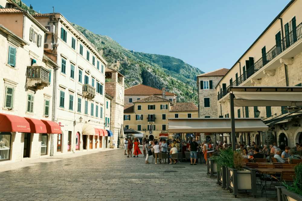 people walking in the street and some are sitting on a cafe -montenegro digital nomad visa