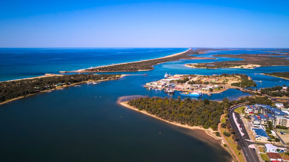 aerial view of blue body of water with islands full of green trees near town