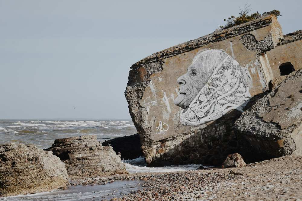 old woman in a drawing on rock near water