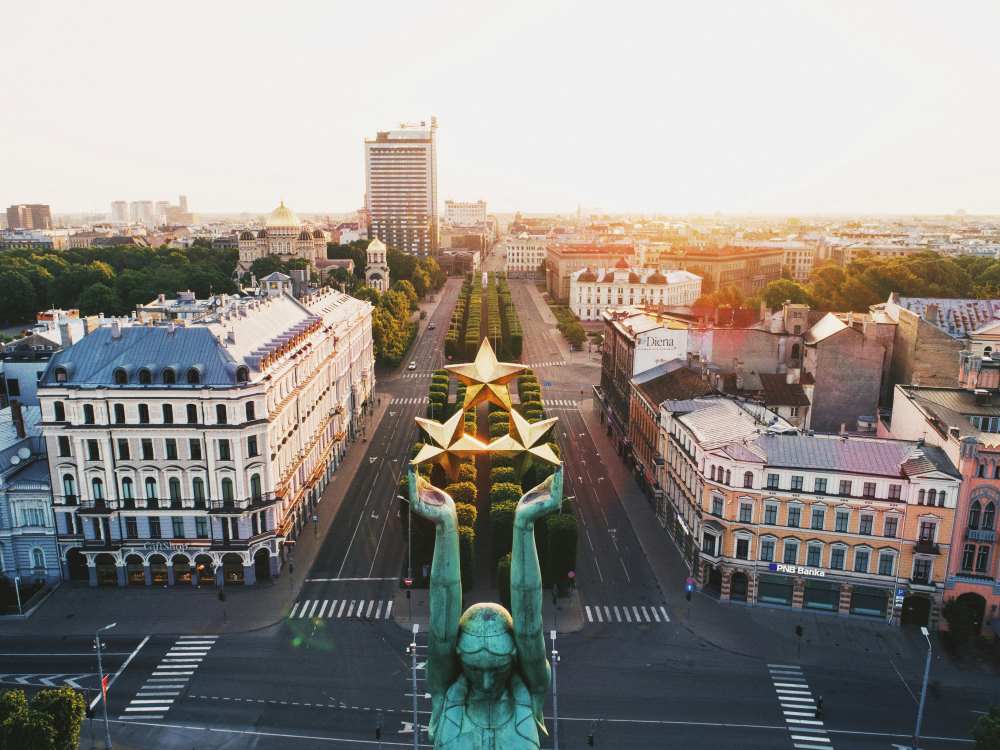 arial view of the city with buildings an a statue holding star in the middle of the street